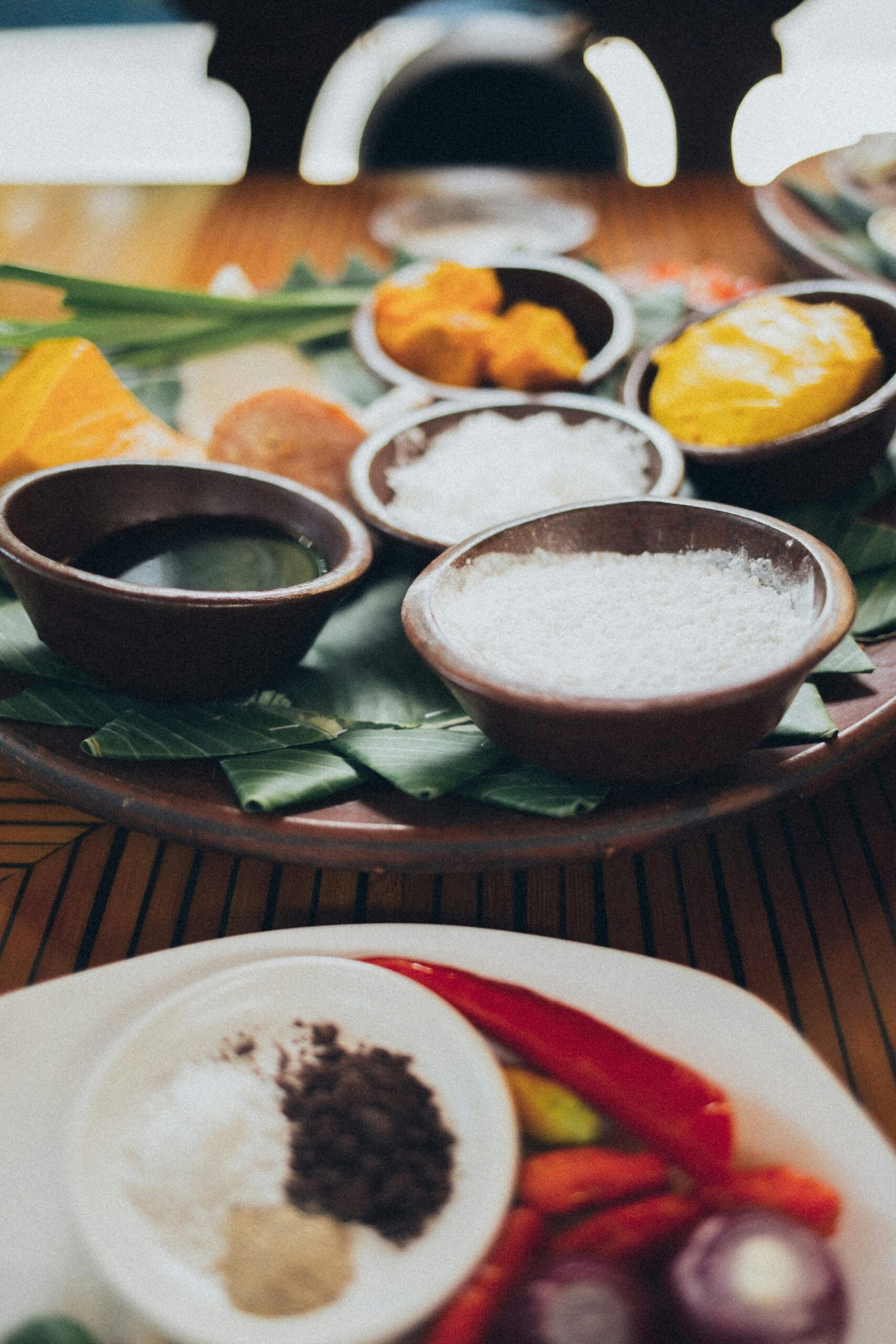 A colorful array of spices and condiments arranged on a wooden table, showcasing culinary diversity.